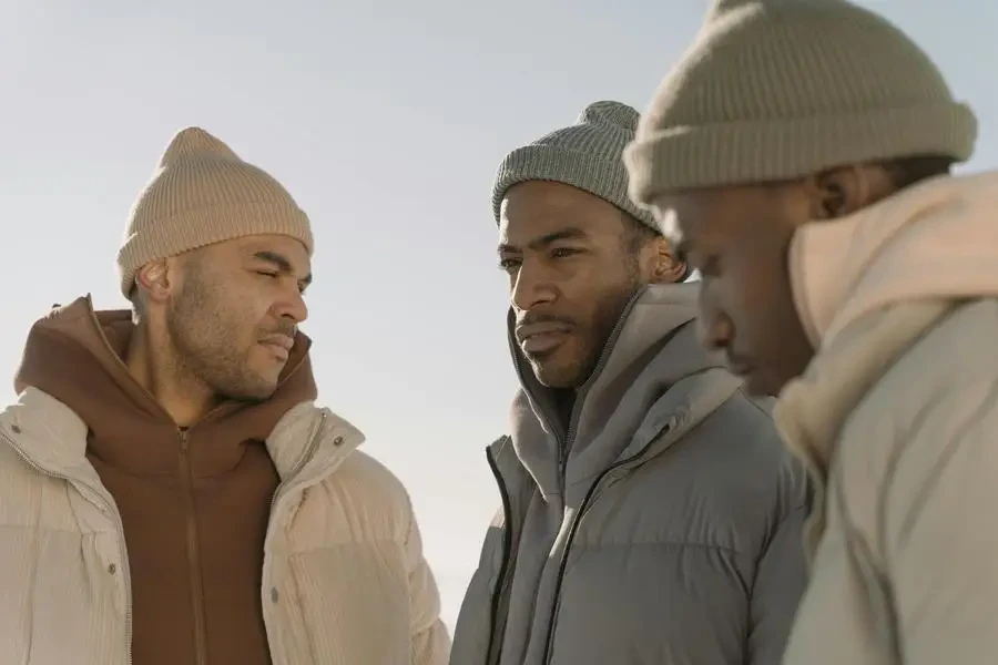 Three Men Wearing Knit Hats and Hoodie with Puffer Jackets by cottonbro studio