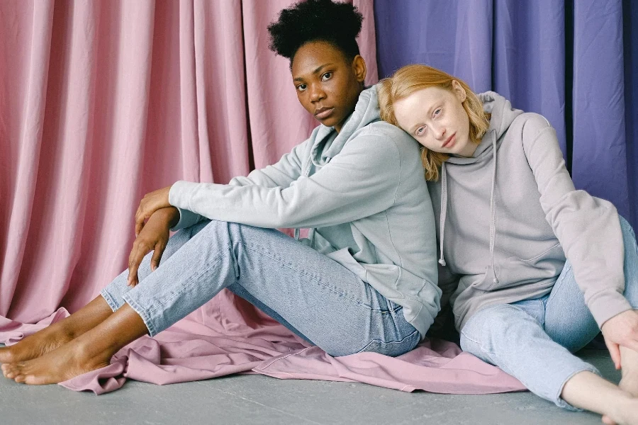 Two Women Sitting on Floor with Textile