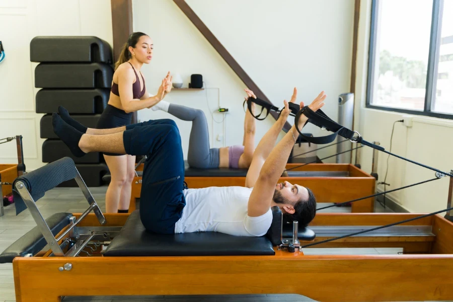 Deux personnes effectuent des exercices sur un lit réformateur Pilates