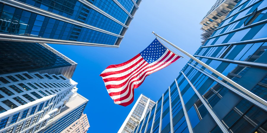 Bendera AS dan gedung pencakar langit kaca kontemporer di New York