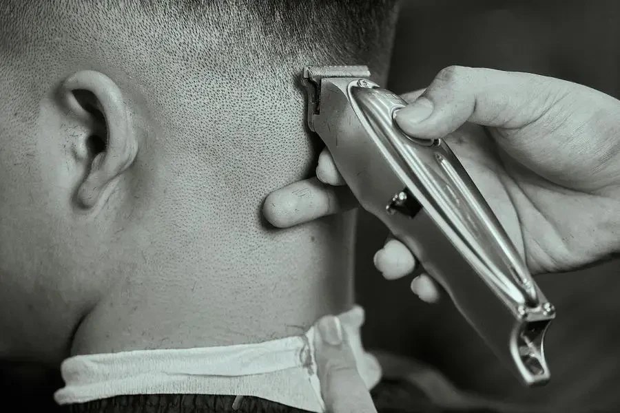 Unrecognizable Hands Trimming Male Haircut with Trimmer by Sự Minh