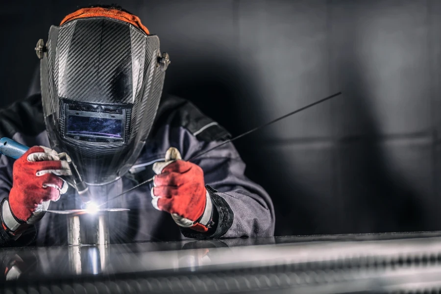 Welder industrial worker welding with argon machine