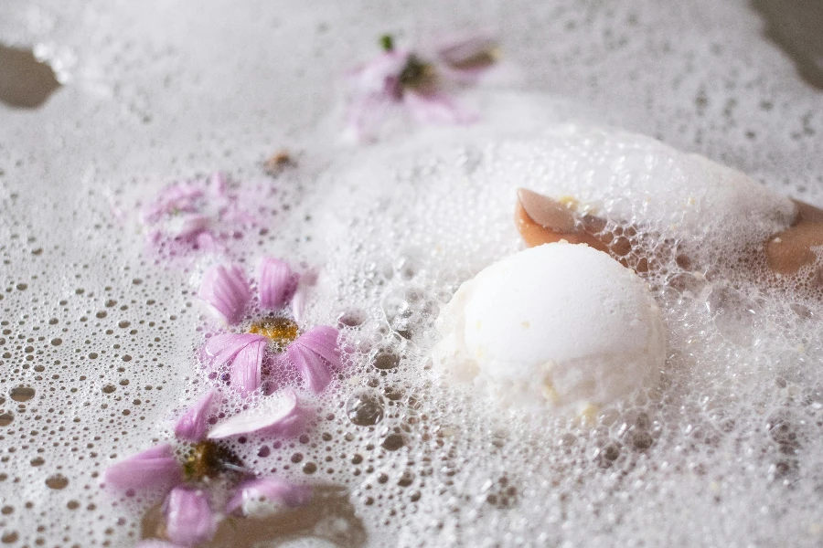 White ball of bath salt on water surface with foam