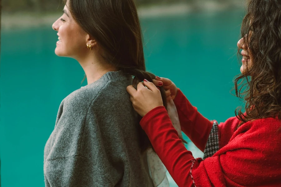 Woman Braiding Her Friends Hair While Standing