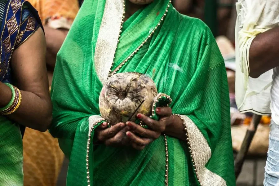 Mulher segurando uma fruta de coco por Yogendra Singh