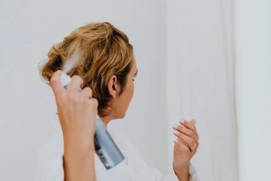 Femme se vaporisant les cheveux par Karolina Kaboompics