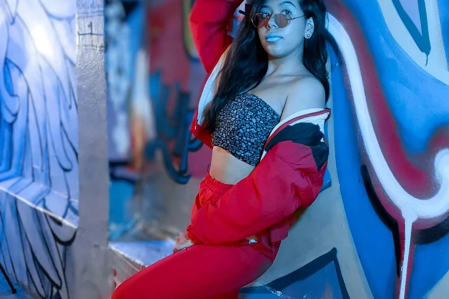 Woman Wearing Red Sweatsuit Posing against a Wall