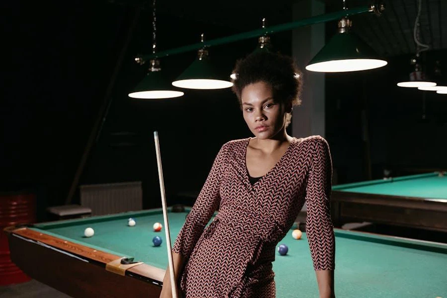 Femme posant avec une queue de billard et de billard