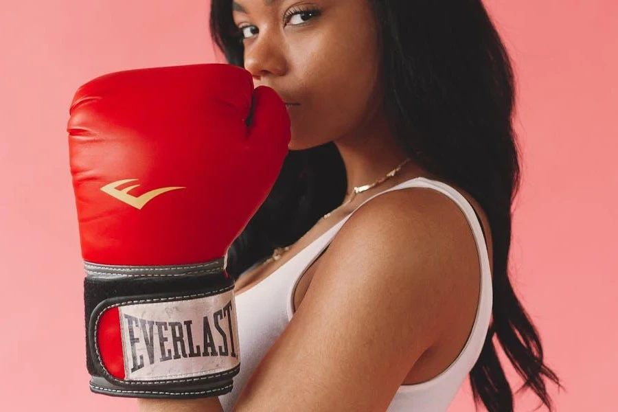 Mujer levantando un guante de boxeo cerca de su cara