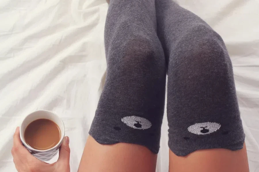 Woman wearing cozy warm wool socks close up on feet