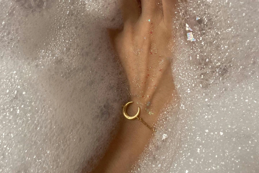 Woman with bracelet taking bath with foam