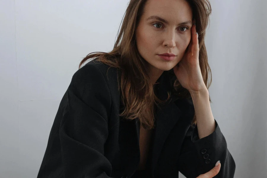 Young Brown Haired Woman Sitting in Elegant Black Suit