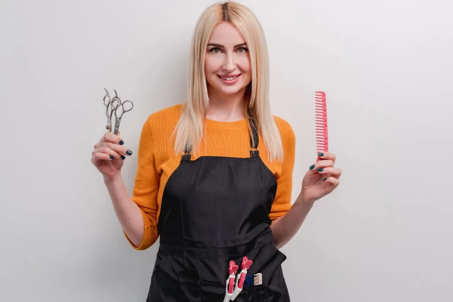 A female hairdresser with a brush and scissors