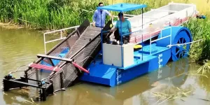 Una cosechadora acuática flotando a orillas de un río lista para trabajar.