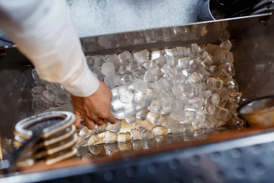 il barista raccoglie il ghiaccio per preparare cocktail alcolici. primo piano