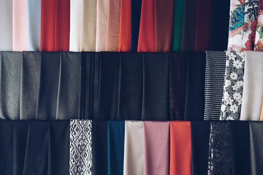 Bir rafta düzenlenmiş renkli kumaşlar