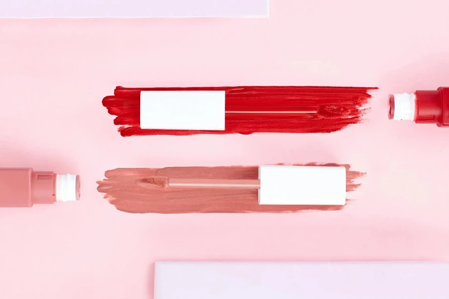 Different lipstick shades on a pink background