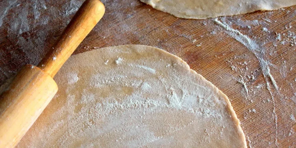 pâte et farine sur une planche de bois