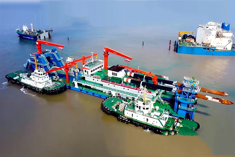 dredger at work surrounded by supporting tugs