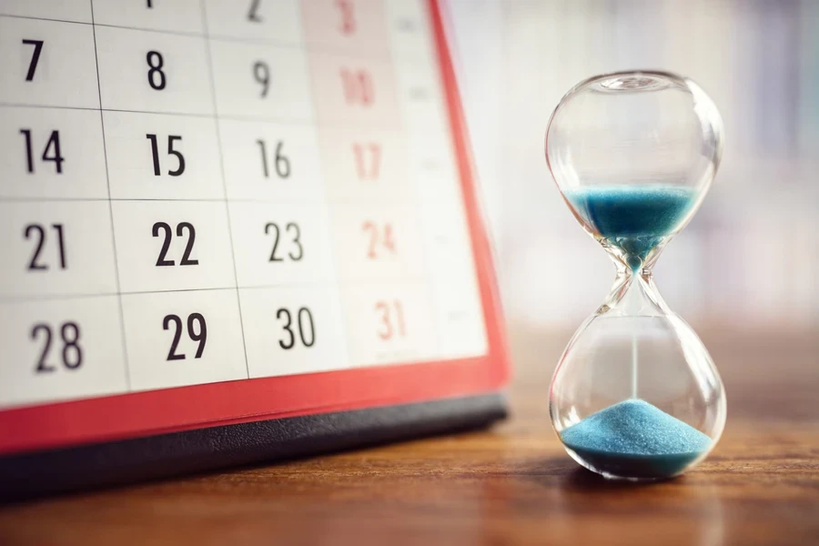 hourglass and calender on a table