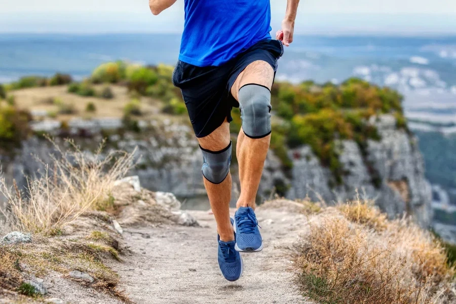 legs runner man in knee pads running mountain trail