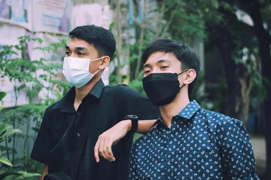 Young Men in Polo Wearing Face Mask while Looking Afar