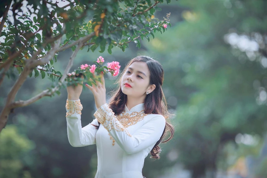 امرأة تحمل زهرة بتلات وردية