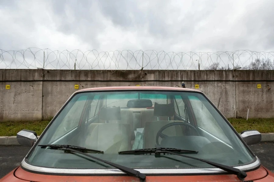 Foto Aproximada De Um Carro Vermelho Perto De Um Muro De Concreto