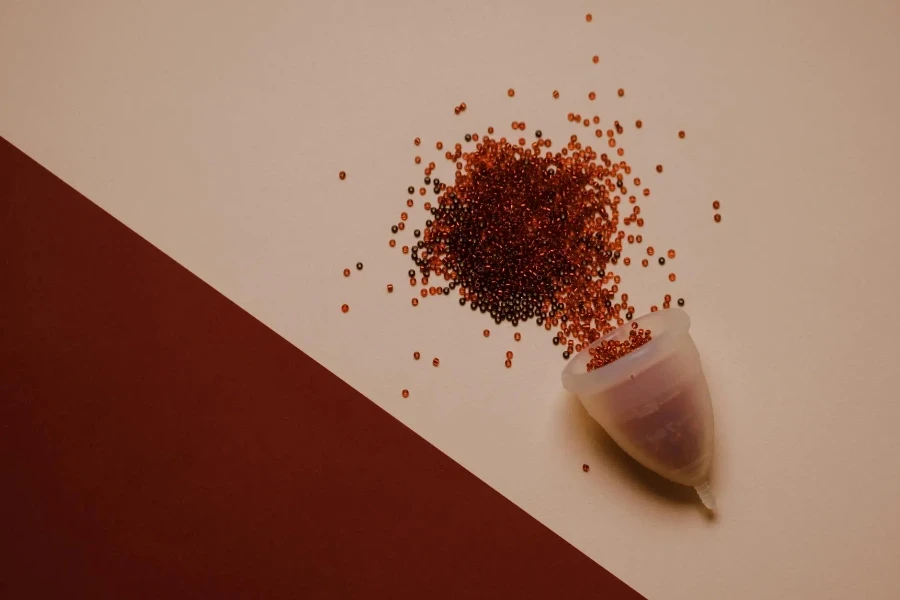 Coppetta mestruale in silicone su superficie rosa