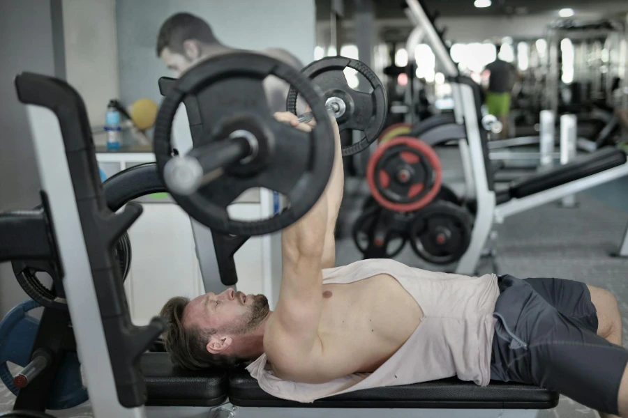 Strong sportsman doing bench press during workout