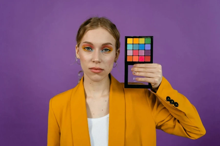 Woman in Yellow Blazer Holding an Eyeshadow Palette