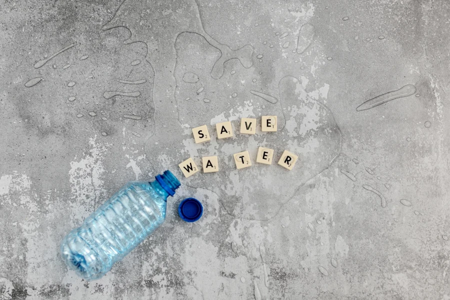 Cubi con lettere e bottiglia di plastica con acqua versata
