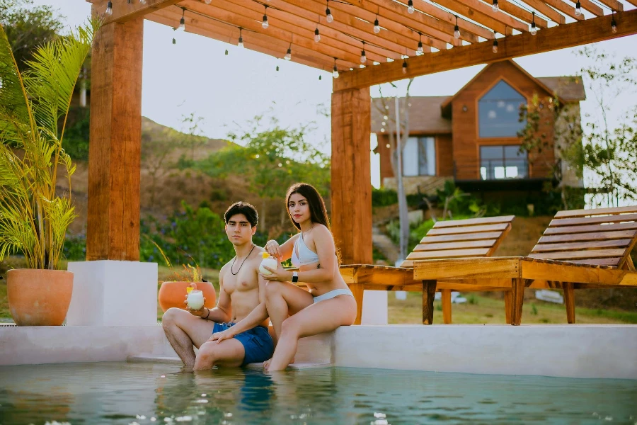 Couple assis dans la piscine avec terrasse en bois