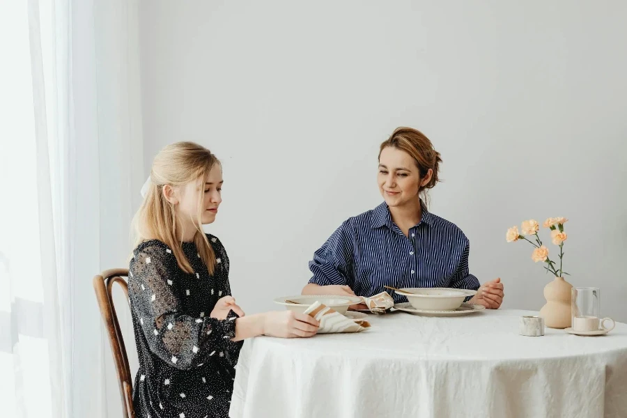 Donna e ragazza adolescente al tavolo da pranzo