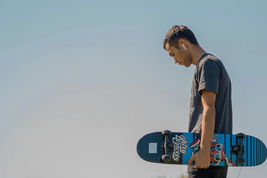 Mann hält ein Skateboard