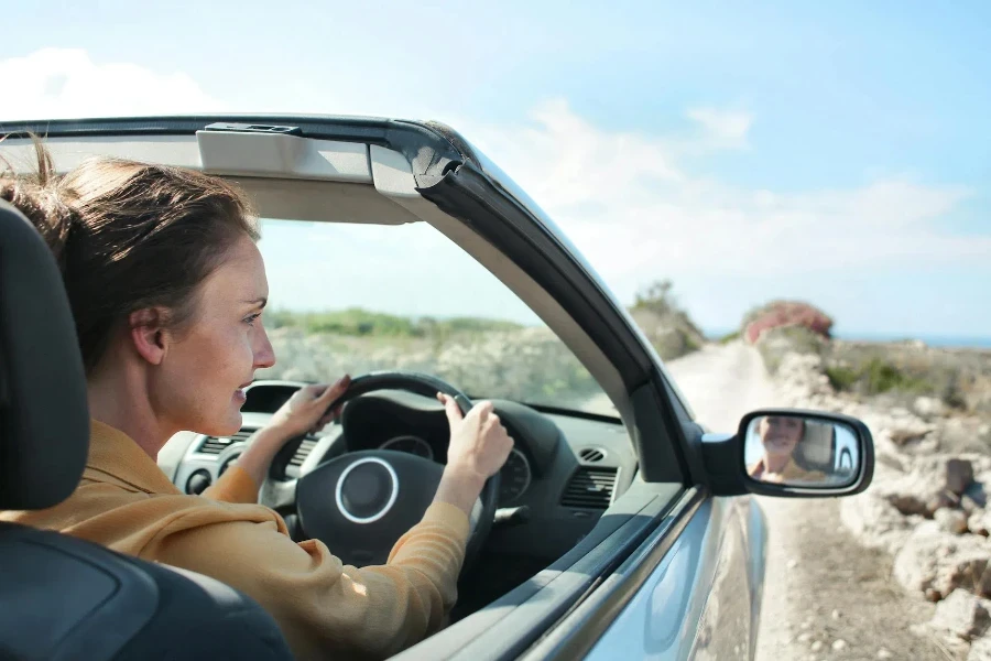 車を運転する茶色のジャケットを着た女性