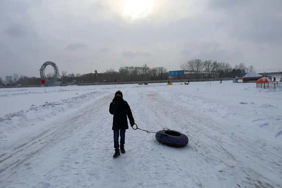 Uma criança arrastando um tubo de neve