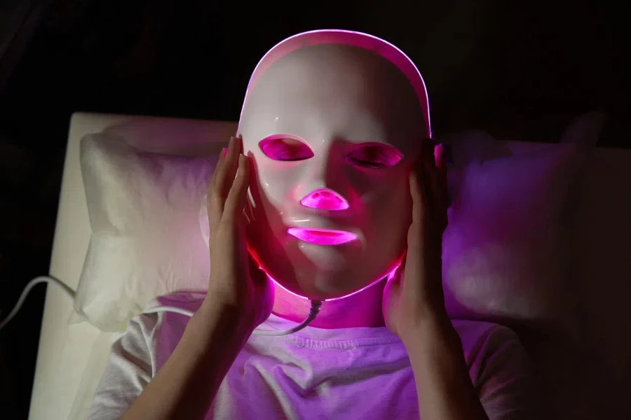 Person, die eine LED-Gesichtsmaske verwendet