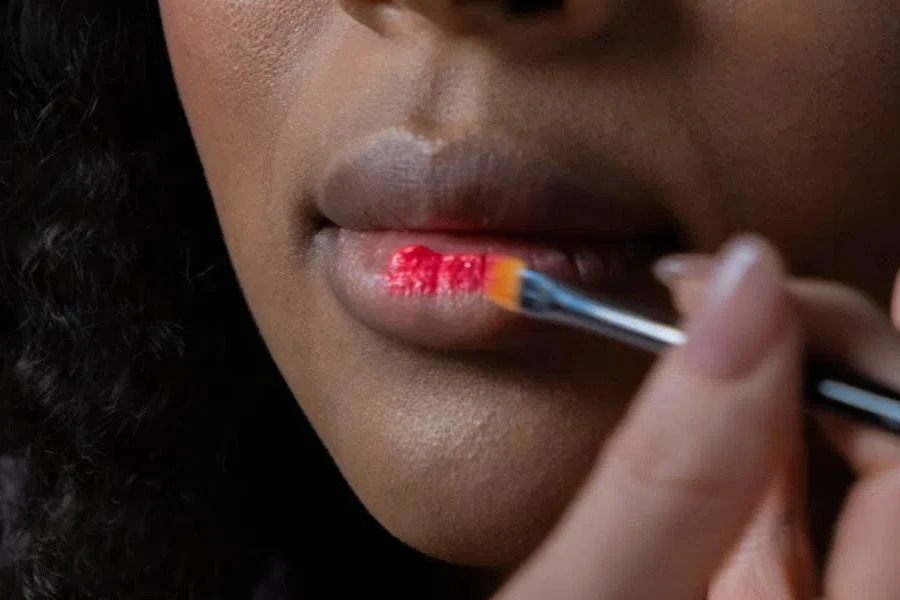 Femme utilisant une tache rouge vif sur les lèvres