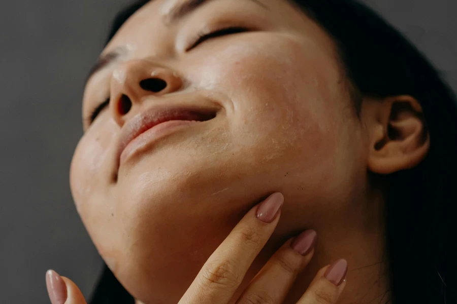 Une femme se touchant le cou avec les yeux fermés