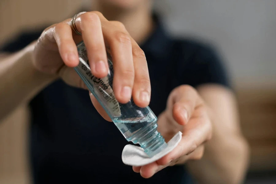 Uma mulher de camisa preta derramando toner em um algodão