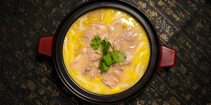 Un plato de sopa con carne y verduras.