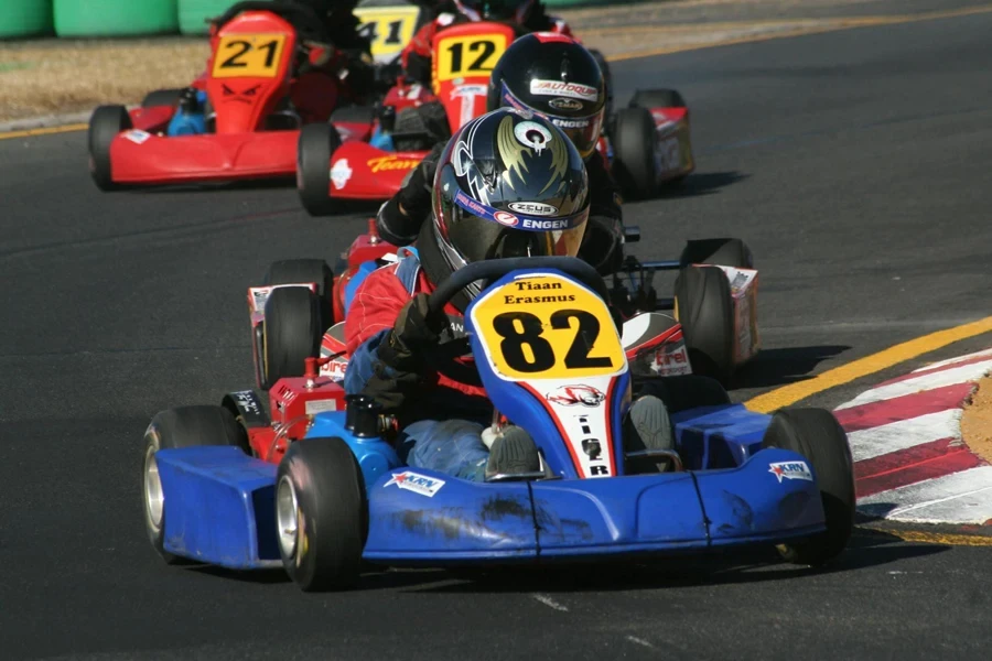 Um homem usando um capacete preto correndo em um kart