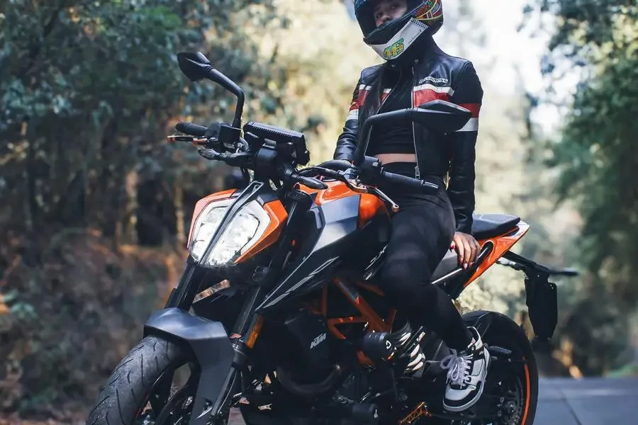 Uma pessoa com capacete pilotando uma motocicleta laranja por Jon