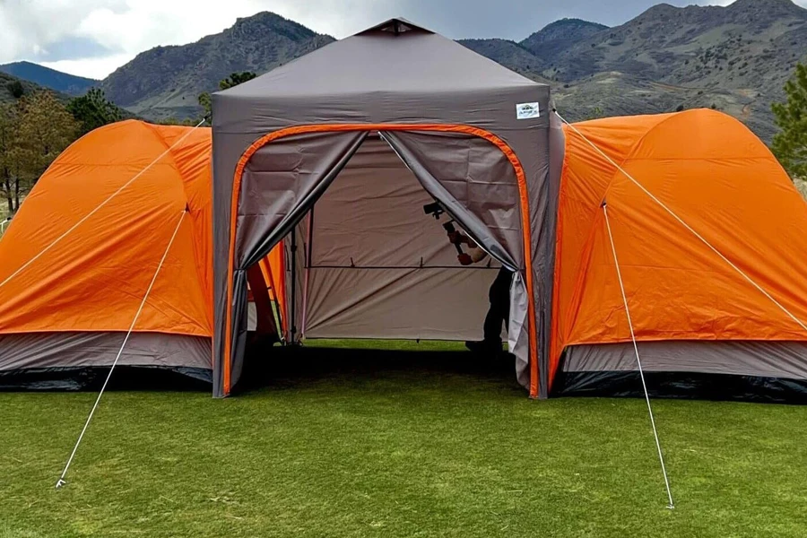 A pop-up canopy in front of a dome tent