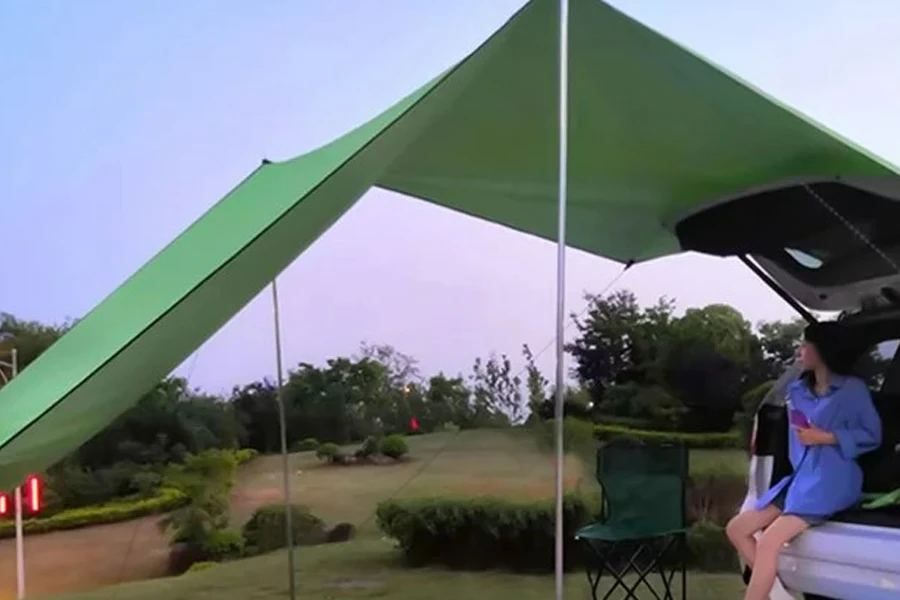 A sun shelter set up near a car