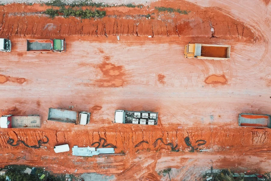 Vista aérea de camiones en un terreno de suelo naranja