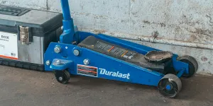 Voiture d'ascenseur de cric d'outil bleu pour la réparation à côté d'une boîte à outils