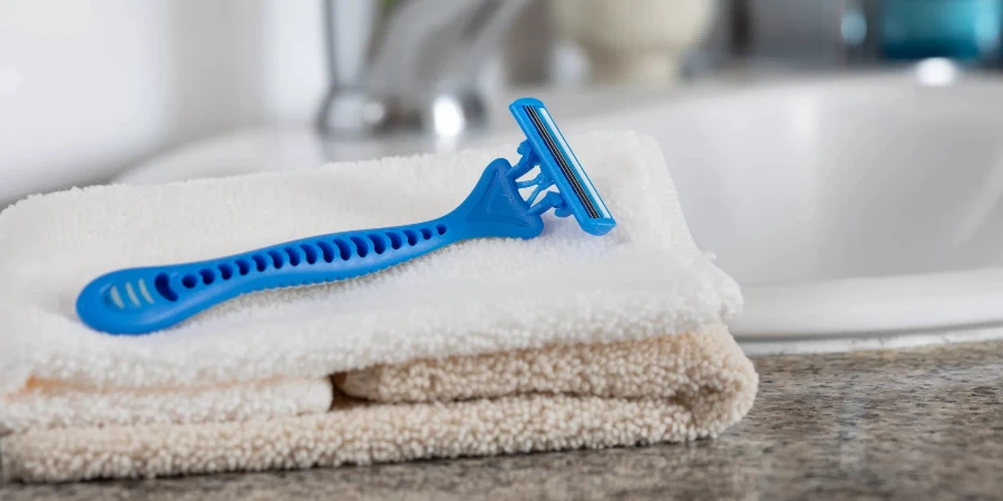 Blue razor and handkerchief on white basin in a bathroom