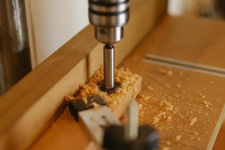 Boring machine drilling hole in wooden plank by Ono Kosuki